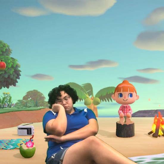 An I-Create Lab student assistant appears to be sitting on a beach in the video game Animal Crossing using Green Screen technology