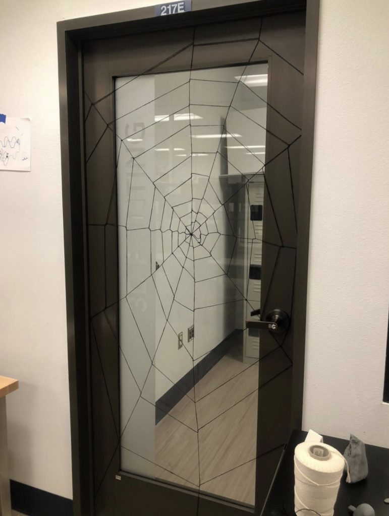 Image of an I-Create Lab door with a spider web made of string strung across it.