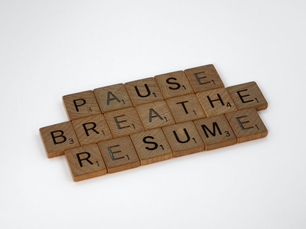 Scrabble letters placed in the order to spell, "Pause, Breathe, Resume."